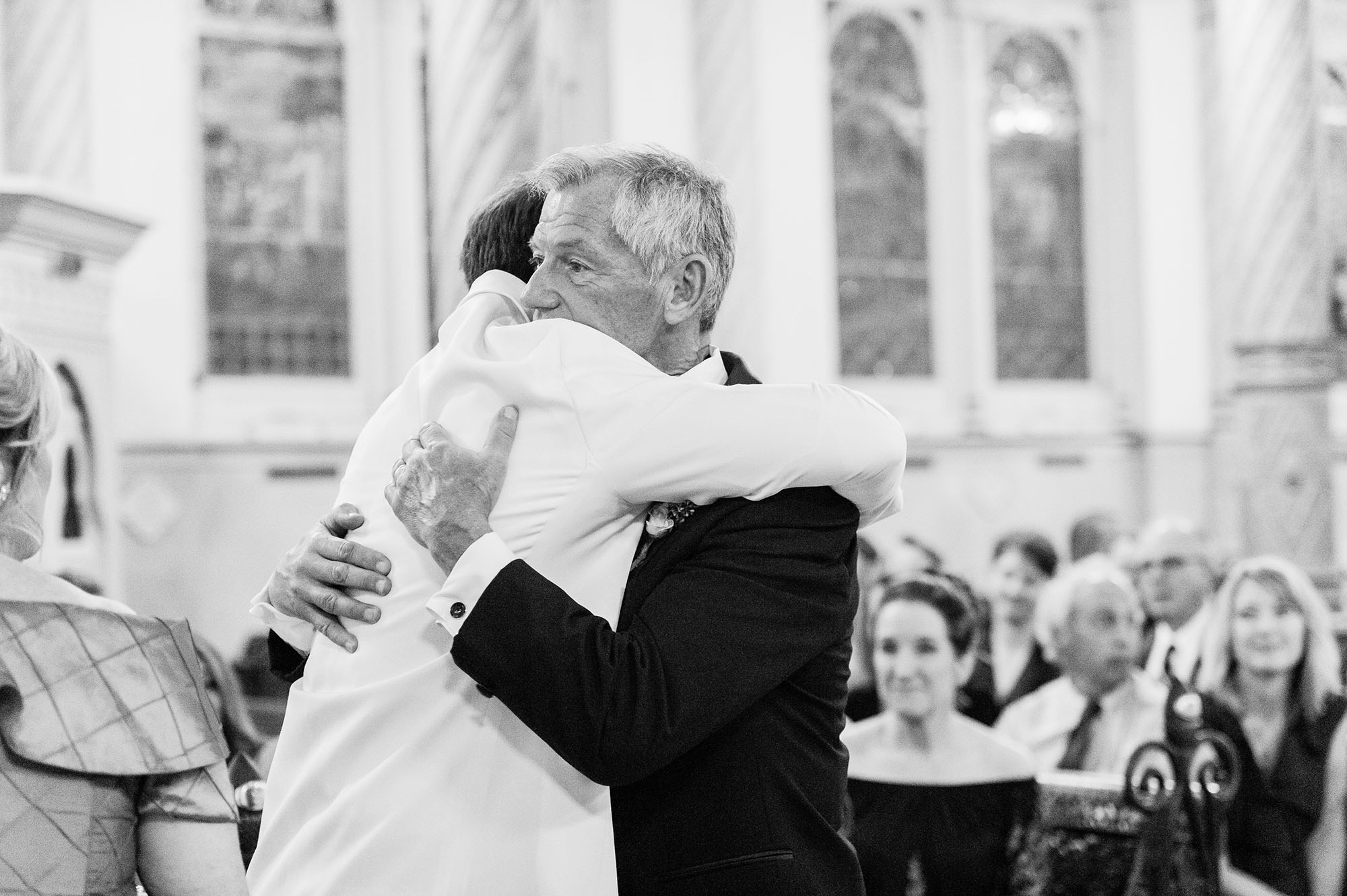Groom hugging dad in church