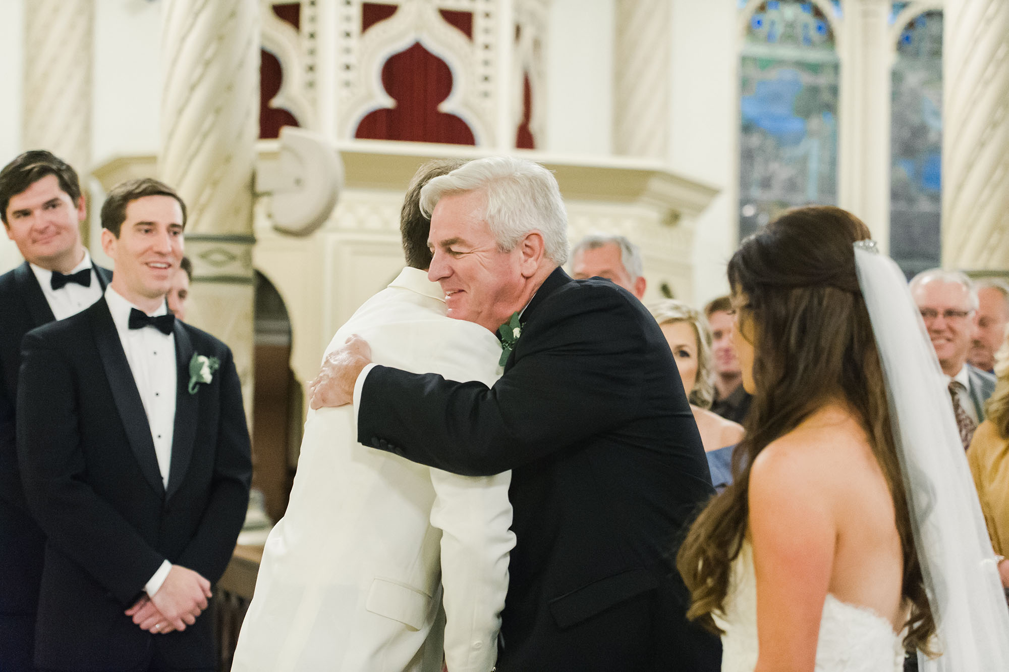 Groom hugging bride's father