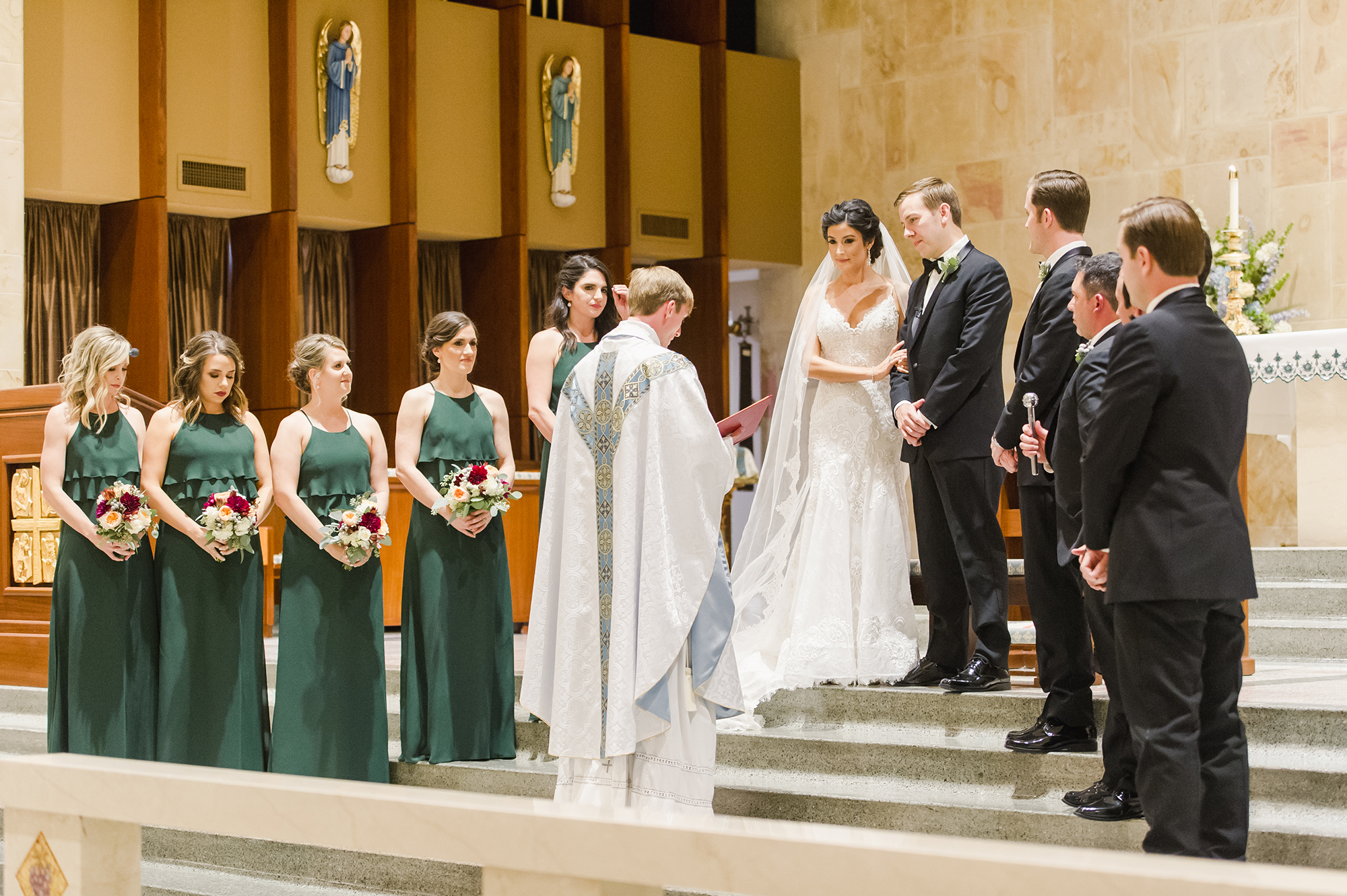 Bride, groom, wedding party and priest during wedding ceremony