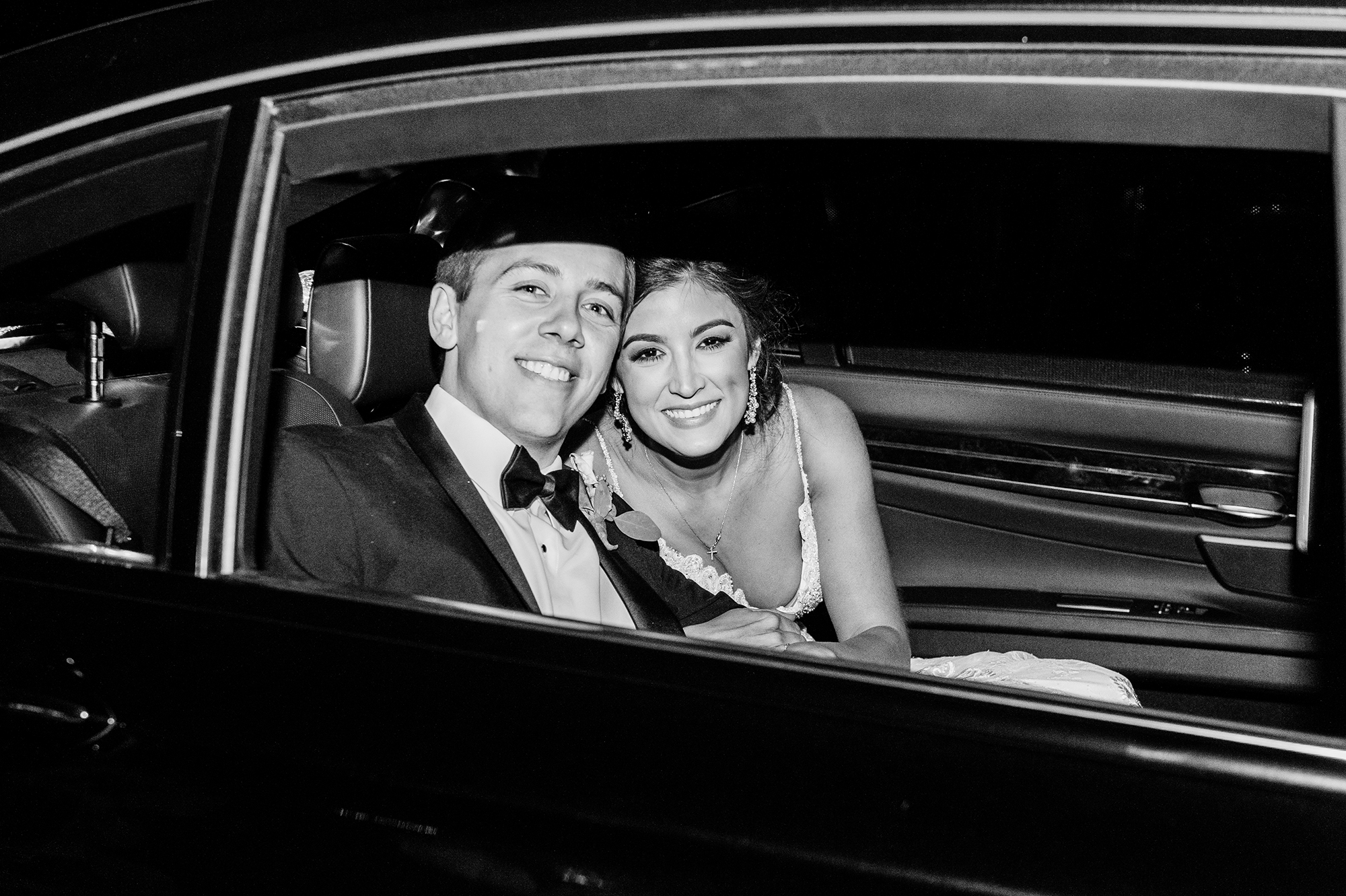 Bride and groom in getaway car after reception