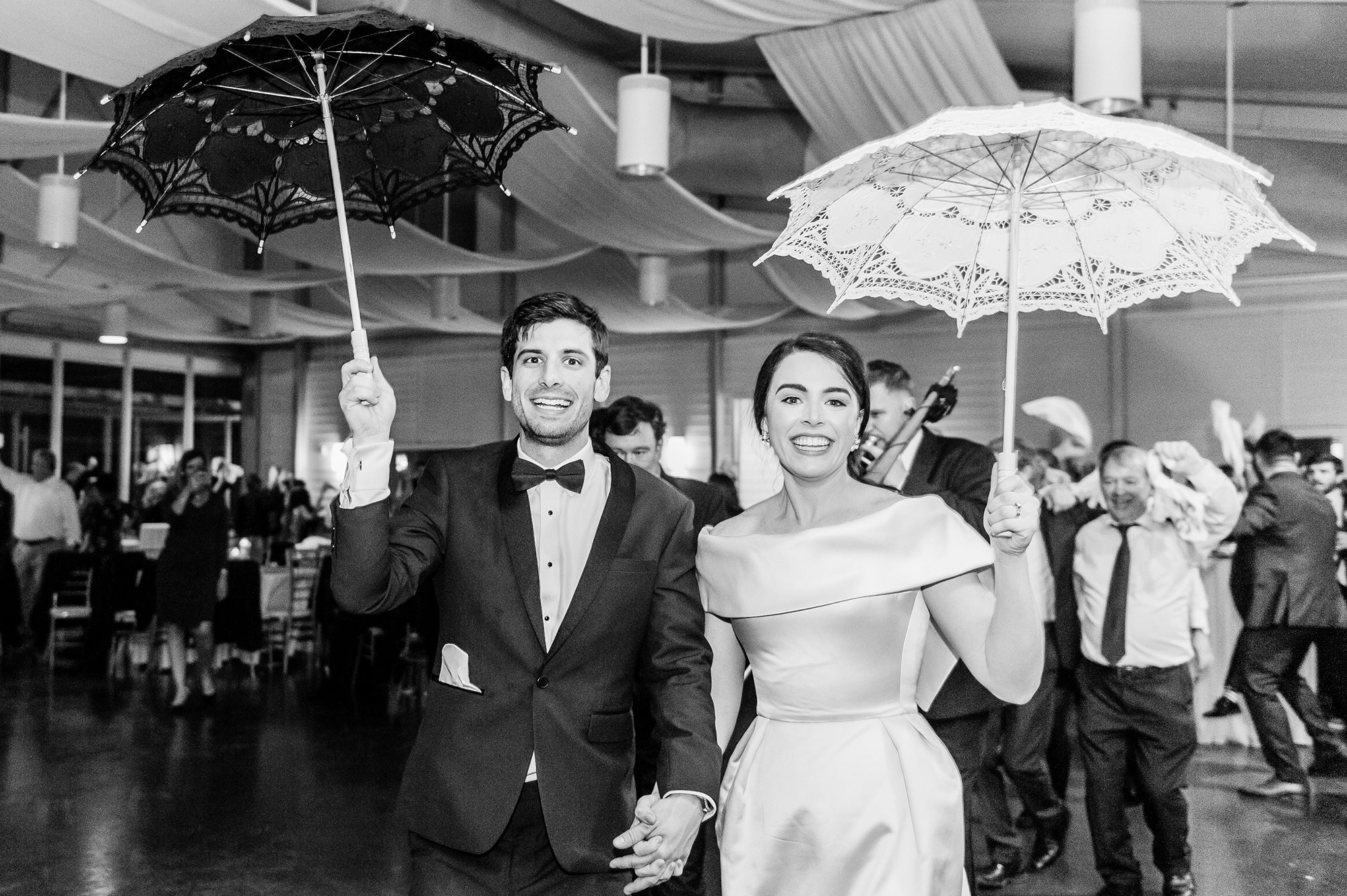 Bride and groom exiting reception with parasols