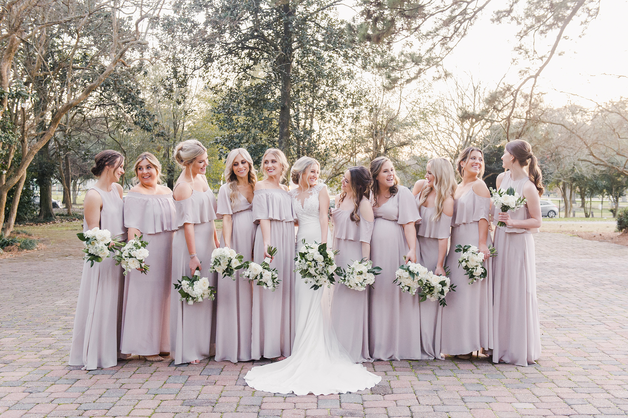 bride laughing with bridesmaids and bouquets